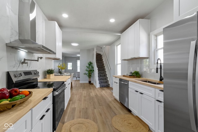 2005 Carrollton Ave, Indianapolis, IN 46202 - kitchen featuring stainless steel appliances, butcher block counters, a sink, wall chimney exhaust hood, and recessed lighting