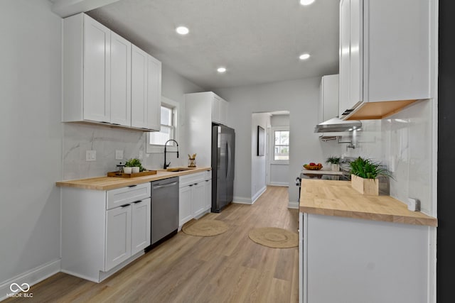 2005 Carrollton Ave, Indianapolis, IN 46202 - kitchen with butcher block counters, stainless steel dishwasher, a sink, freestanding refrigerator, and baseboards
