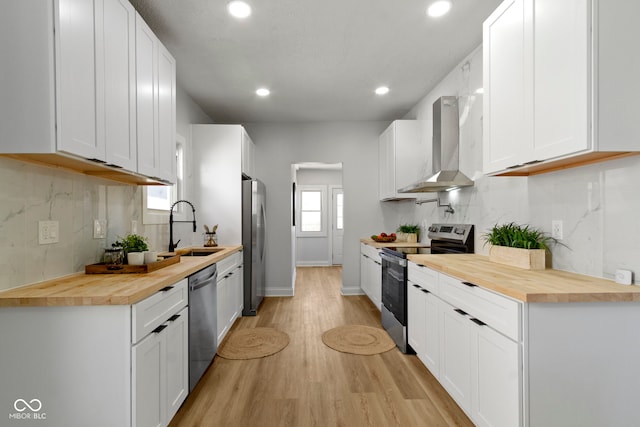 2005 Carrollton Ave, Indianapolis, IN 46202 - kitchen featuring appliances with stainless steel finishes, wooden counters, wall chimney range hood, a sink, and recessed lighting
