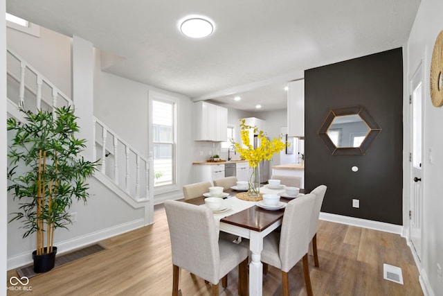 2005 Carrollton Ave, Indianapolis, IN 46202 - dining room featuring stairs, light wood-style floors, baseboards, and recessed lighting