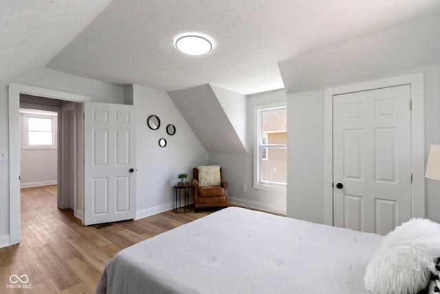 2005 Carrollton Ave, Indianapolis, IN 46202 - bedroom with wood finished floors, baseboards, vaulted ceiling, and a textured ceiling