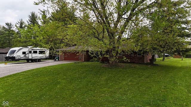 view of yard featuring an attached garage and driveway