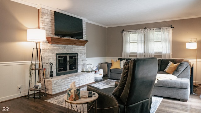 living area featuring crown molding, wainscoting, wood finished floors, and a fireplace