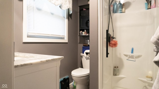 bathroom featuring vanity, a shower, and toilet
