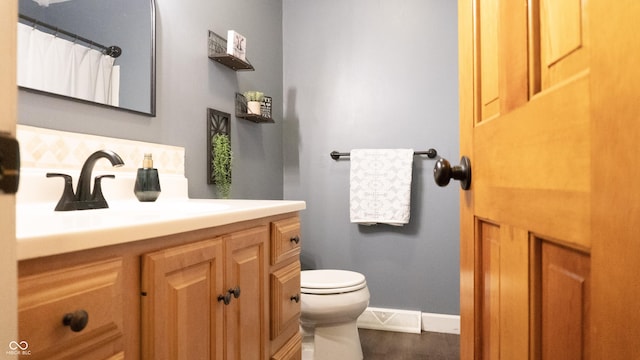 full bath with vanity, baseboards, and toilet
