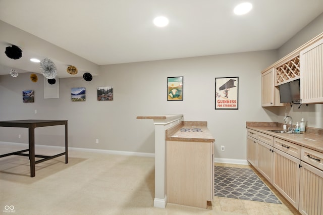 kitchen featuring light countertops, baseboards, and a sink