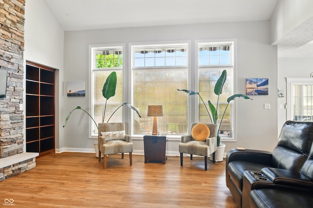 living area with baseboards, plenty of natural light, and light wood-style floors