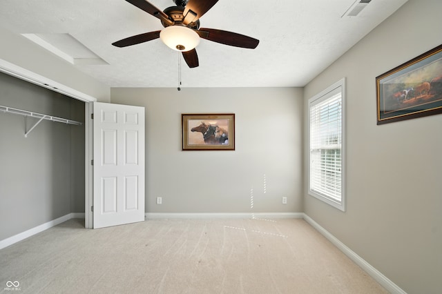 unfurnished bedroom featuring ceiling fan, light colored carpet, baseboards, visible vents, and a closet