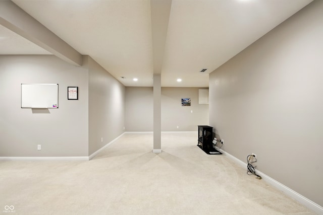 finished below grade area with baseboards, recessed lighting, and light colored carpet