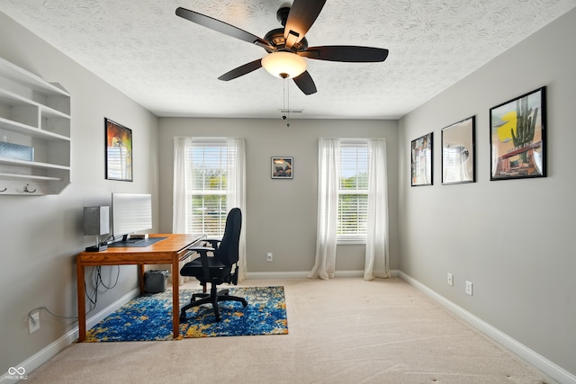 carpeted home office with baseboards, a textured ceiling, and ceiling fan