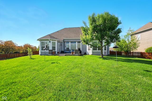 back of house with a fenced backyard, a yard, and a patio area