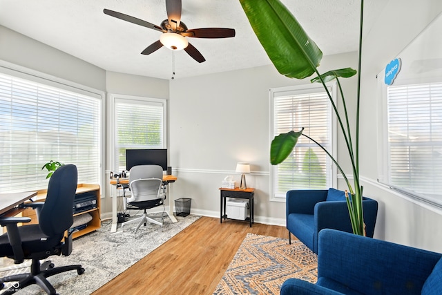 office area with baseboards, a ceiling fan, and wood finished floors