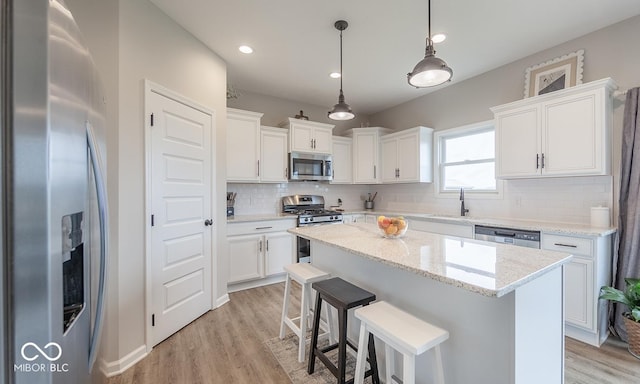 3235 Myrtle Dr, Lapel, IN 46051 - kitchen featuring stainless steel appliances, light wood-type flooring, a kitchen island, tasteful backsplash, and white cabinetry