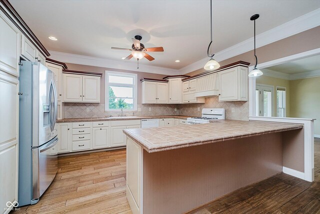 6345 Canak Dr, Avon, IN 46123 - kitchen featuring white appliances, a peninsula, light wood finished floors, a sink, and crown molding