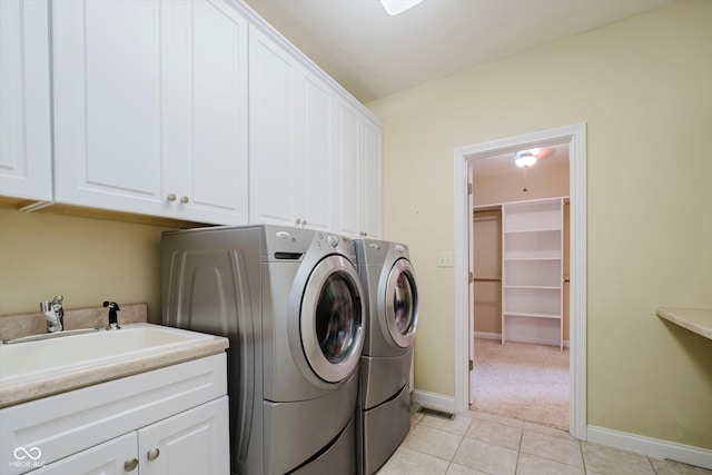 6345 Canak Dr, Avon, IN 46123 - laundry room featuring independent washer and dryer, cabinet space, light tile patterned floors, and baseboards