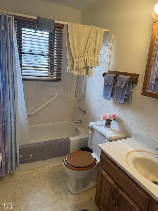 bathroom featuring shower / bath combo, toilet, vanity, and tile walls