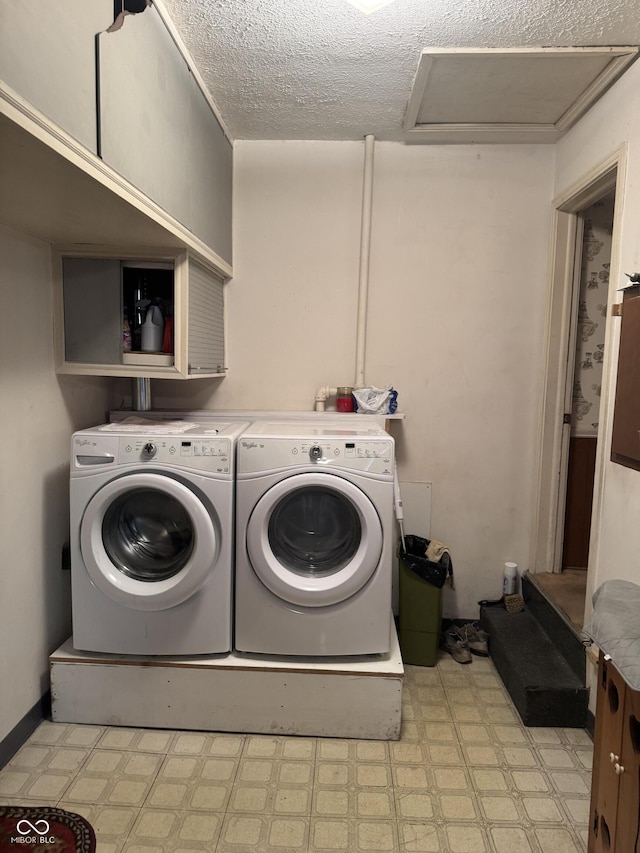 laundry room with washing machine and clothes dryer, attic access, a textured ceiling, light floors, and laundry area