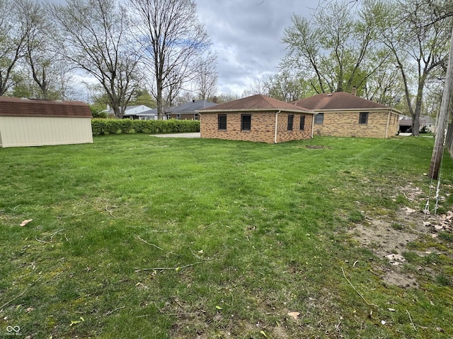 view of yard featuring a storage unit and an outbuilding