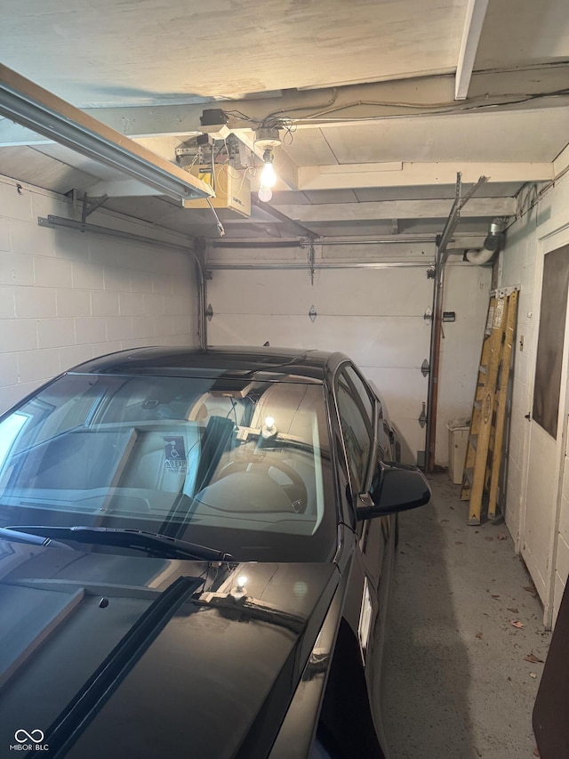 garage with concrete block wall and a garage door opener