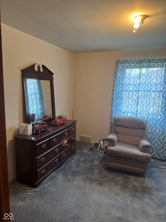 sitting room featuring dark colored carpet and visible vents