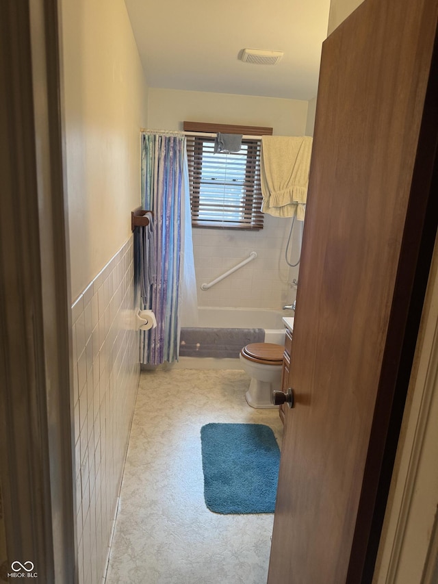 full bathroom featuring tile walls, visible vents, and toilet