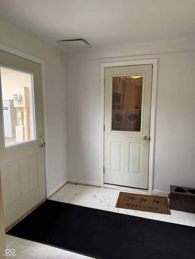 doorway to outside with baseboards and washer / clothes dryer