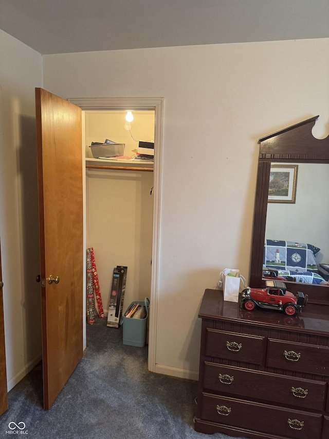 bedroom with dark colored carpet and a closet