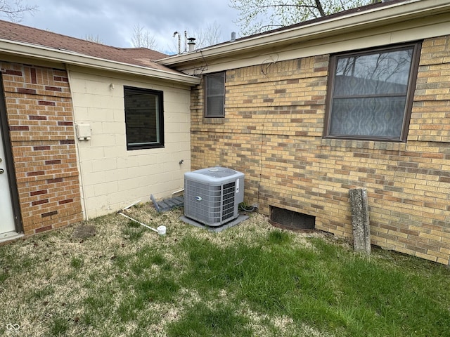view of side of home with cooling unit and brick siding