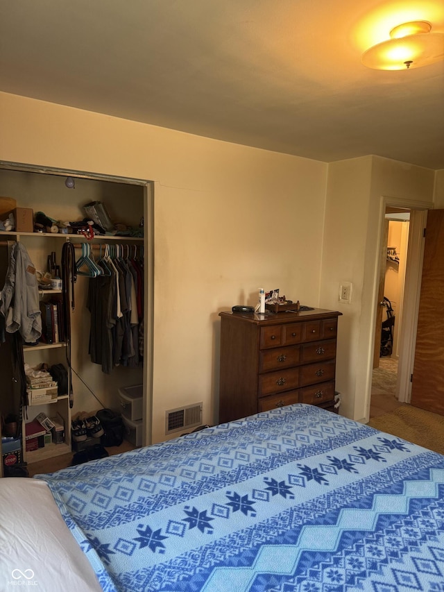 carpeted bedroom featuring visible vents and a closet