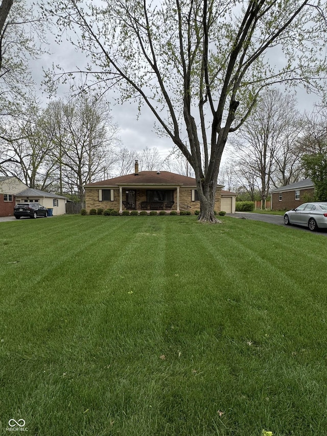 view of yard with aphalt driveway and a garage