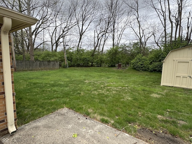 view of yard featuring fence, an outbuilding, and a storage unit