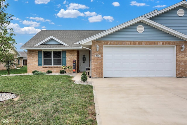 view of front of property featuring a front lawn, concrete driveway, brick siding, an attached garage, and a shingled roof