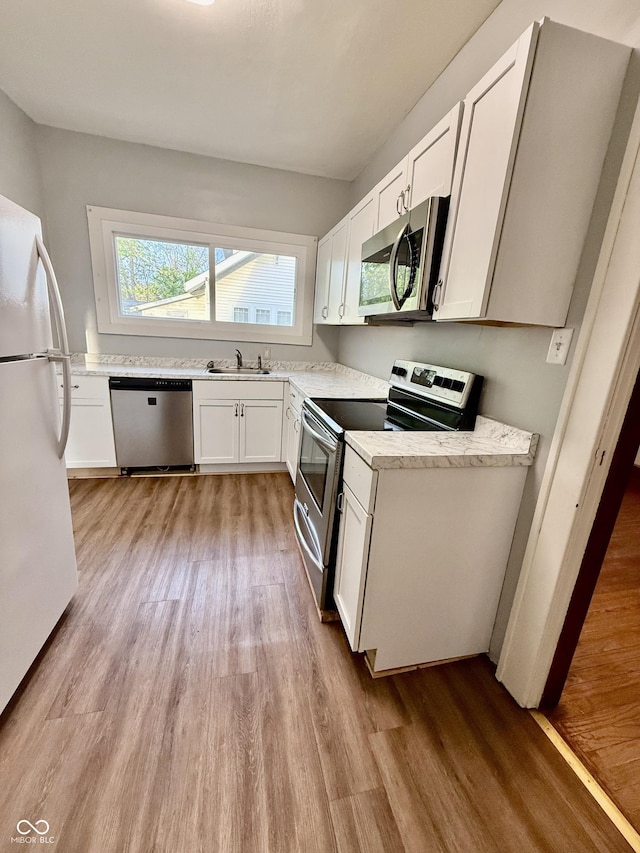 11 Highland St, Greencastle, IN 46135 - kitchen featuring a sink, white cabinets, appliances with stainless steel finishes, and light wood-type flooring