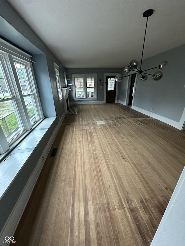 532 S 6th St, Clinton, IN 47842 - unfurnished living room with a chandelier, wood finished floors, and baseboards