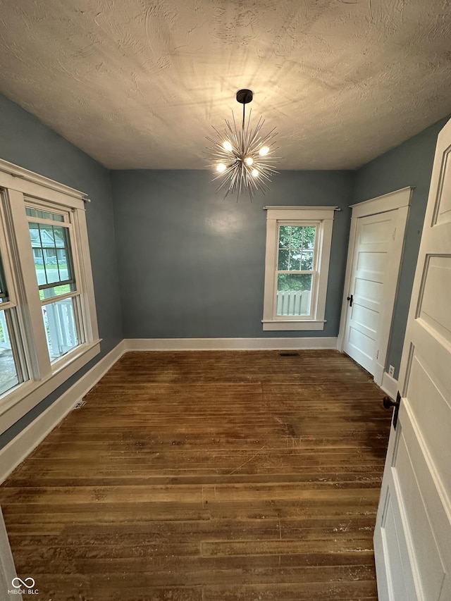 532 S 6th St, Clinton, IN 47842 - unfurnished dining area featuring a chandelier, dark wood-style floors, baseboards, and plenty of natural light