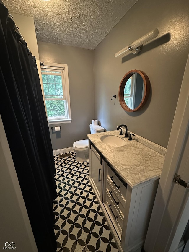 532 S 6th St, Clinton, IN 47842 - bathroom with a textured ceiling, vanity, toilet, tile patterned floors, and baseboards