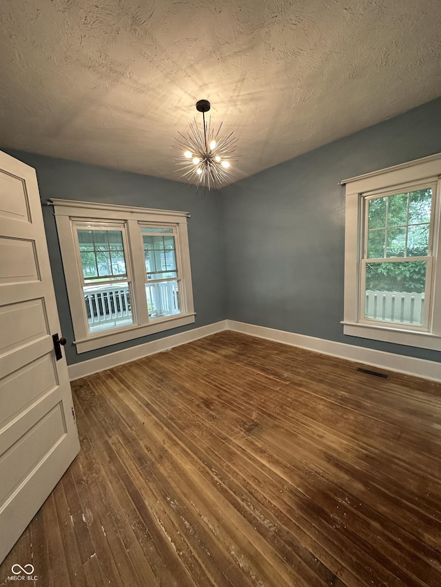 532 S 6th St, Clinton, IN 47842 - spare room featuring dark wood finished floors, a chandelier, baseboards, and a textured ceiling