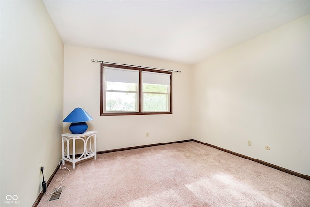 carpeted spare room with baseboards and visible vents