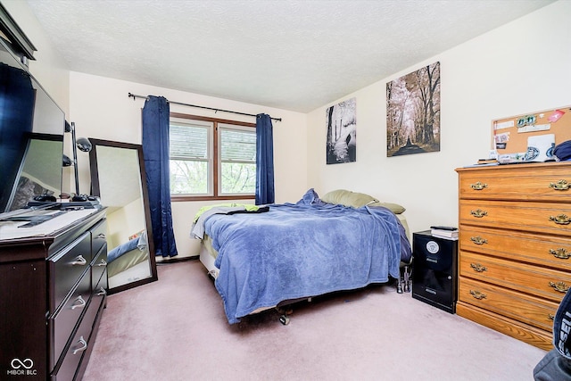 bedroom featuring a textured ceiling and light colored carpet