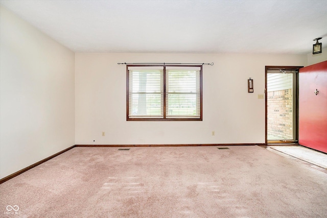 carpeted spare room featuring baseboards and visible vents