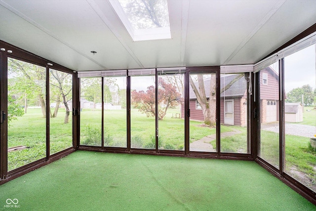 unfurnished sunroom featuring carpet flooring, a skylight, and floor to ceiling windows