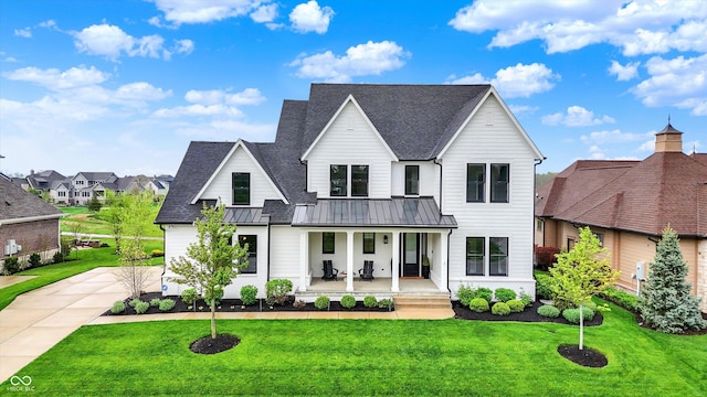 284 Chatham Hills Blvd, Westfield, IN 46074 - view of front of property featuring a front lawn, covered porch, a standing seam roof, a shingled roof, and metal roof