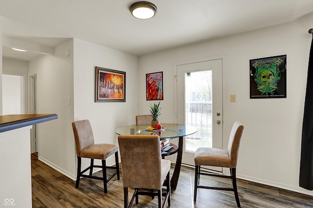 dining space with dark wood-type flooring and baseboards