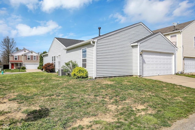 view of side of home with driveway, a yard, and a garage