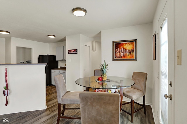 dining area featuring baseboards and dark wood finished floors