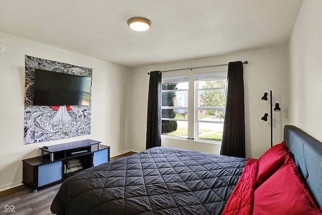 bedroom featuring baseboards and dark wood-type flooring