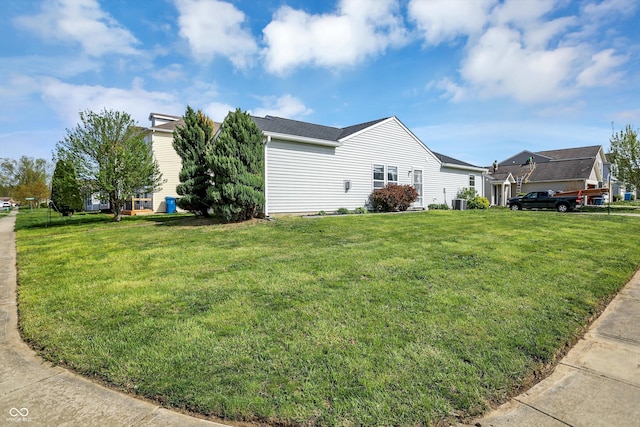 view of side of property with a yard and cooling unit