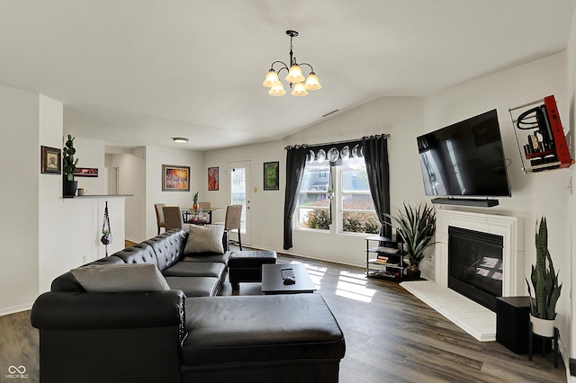 living area with lofted ceiling, an inviting chandelier, wood finished floors, baseboards, and a glass covered fireplace