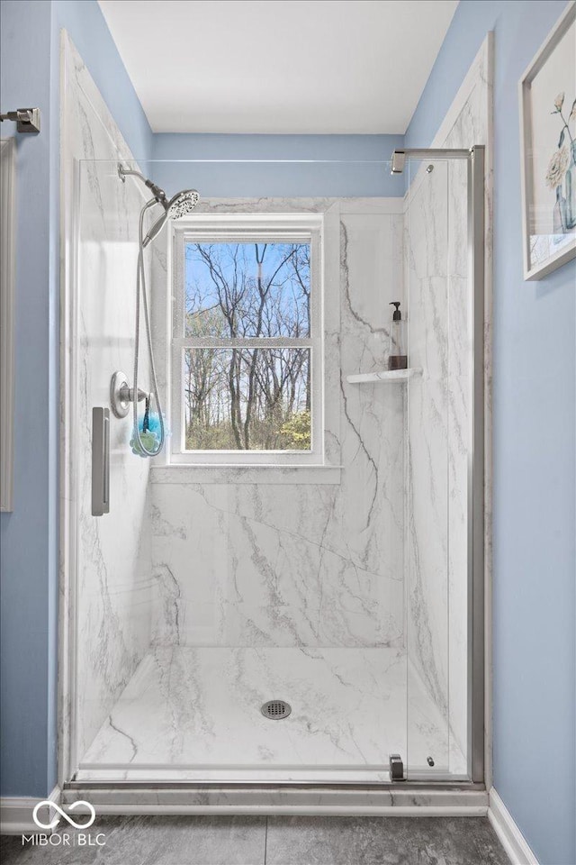 bathroom featuring a marble finish shower