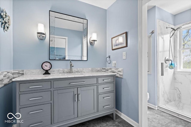 full bath with vanity, toilet, marble finish floor, baseboards, and a stall shower